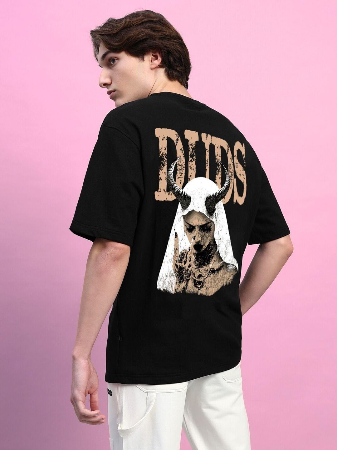 Oversized black T-shirt with creative horned figure print on back, worn by a person against a pink background. Premium cotton fabric.