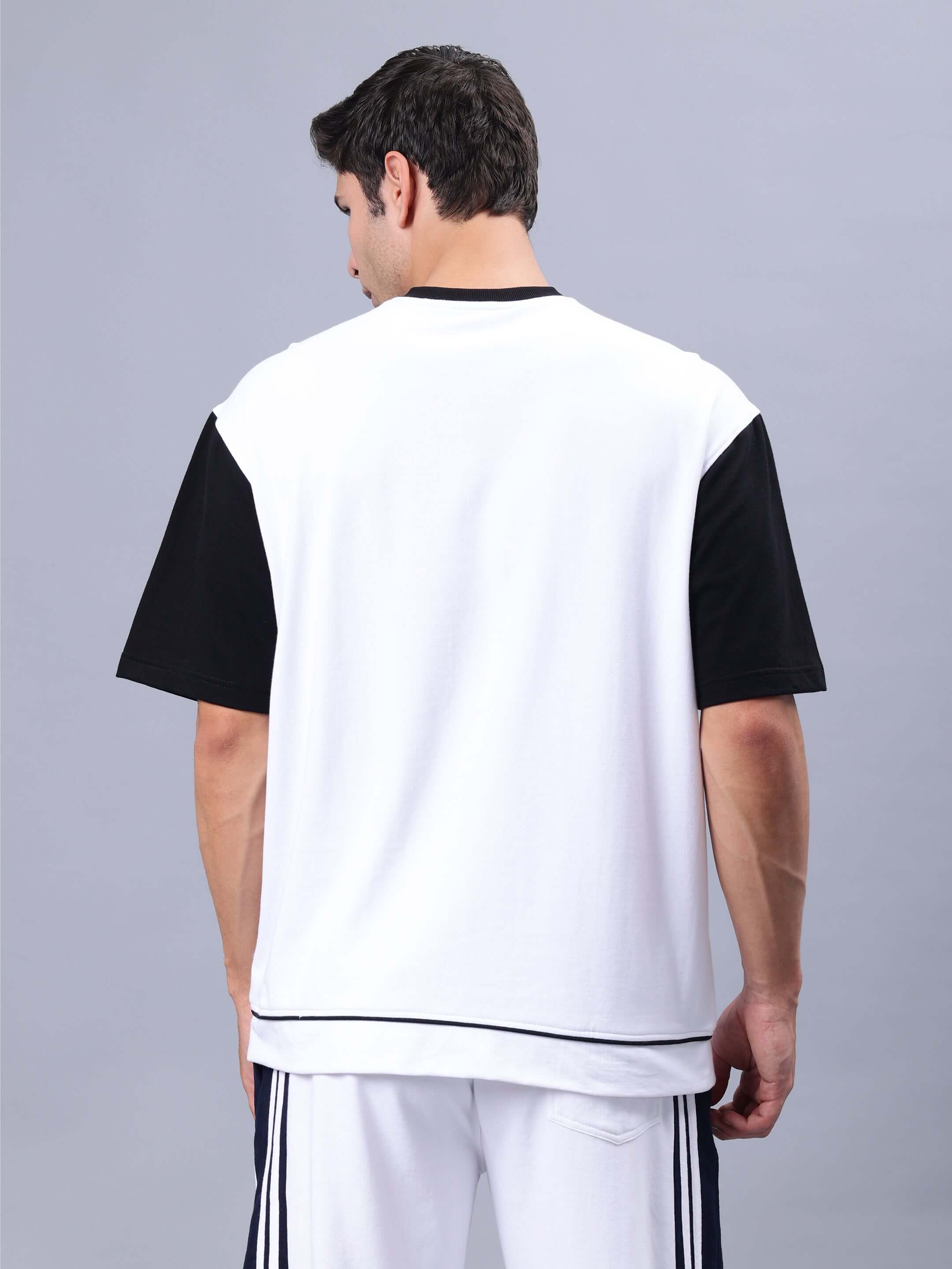 Back view of a male model wearing a HUNK oversized t-shirt in white and black, made of premium heavy gauge fabric with cotton and elastane.