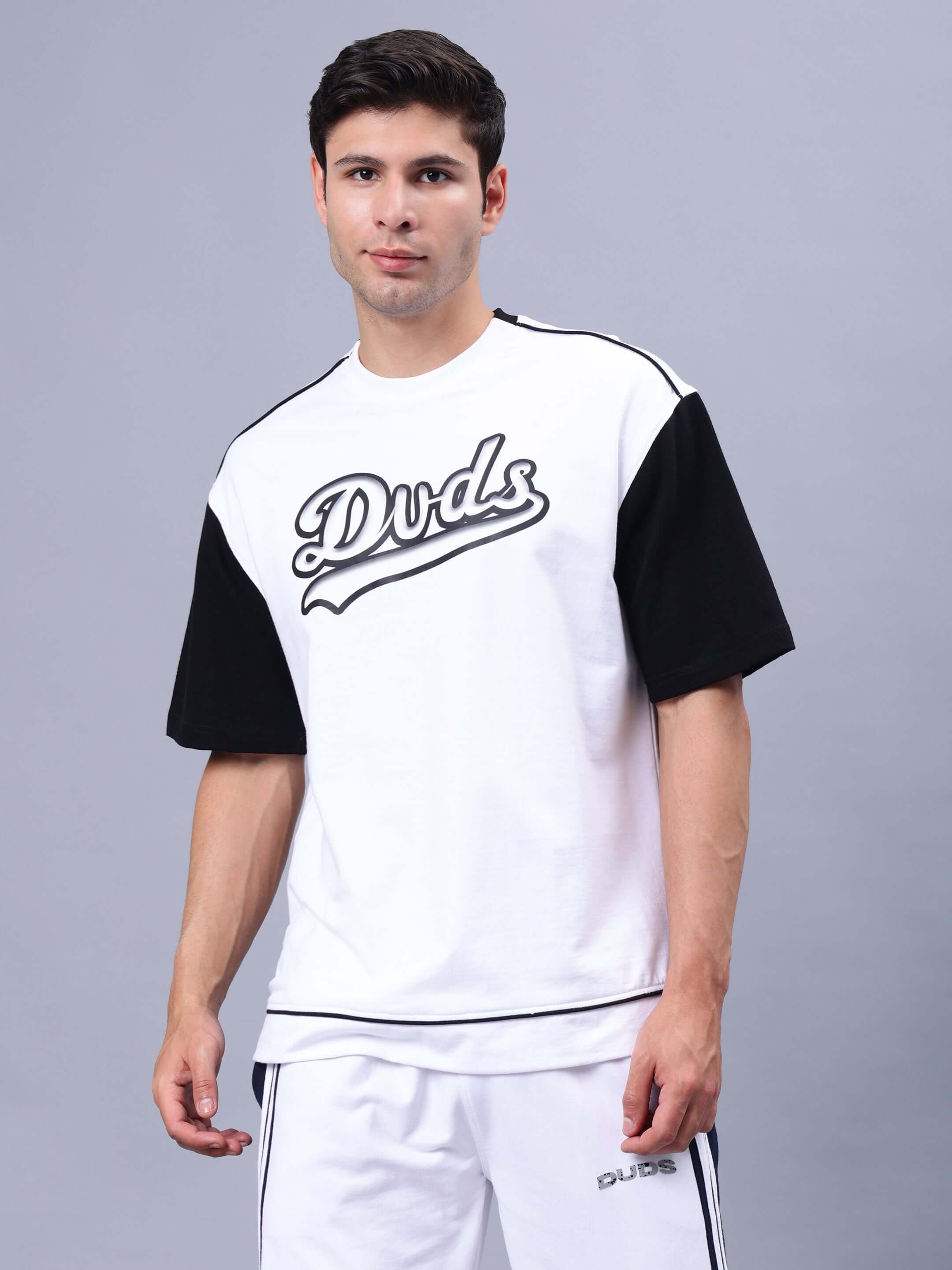 Over-sized white and black t-shirt on a model, made from premium cotton French Terry, showcasing 'Duds' text, ideal for casual wear.