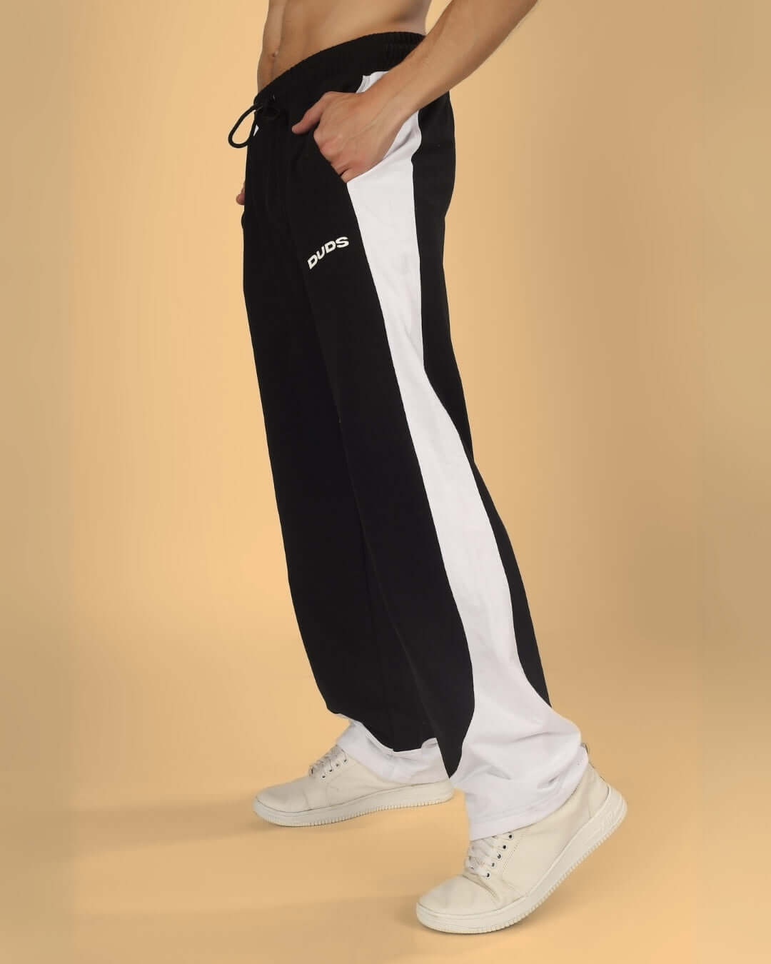 HURTLE Baggy Joggers in black and white, customizable fit by DUDS, worn by model with white sneakers.