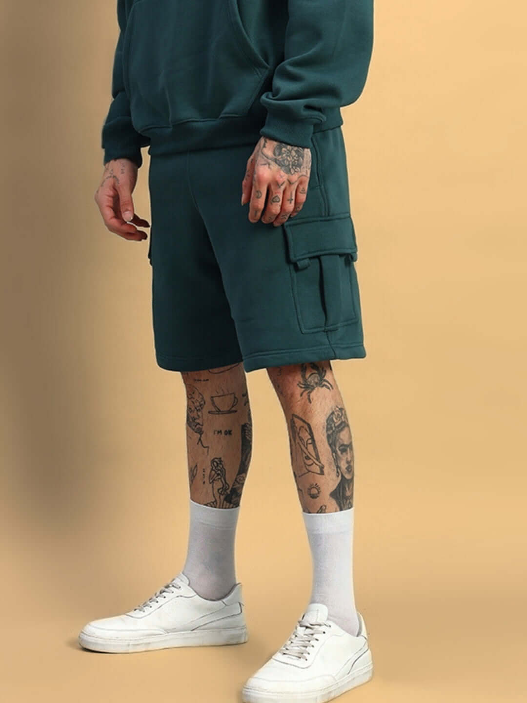 Person wearing HUSKY FLEECE SOLID CARGO SHORTS TEAL GREEN with white sneakers, showcasing casual and comfortable style.