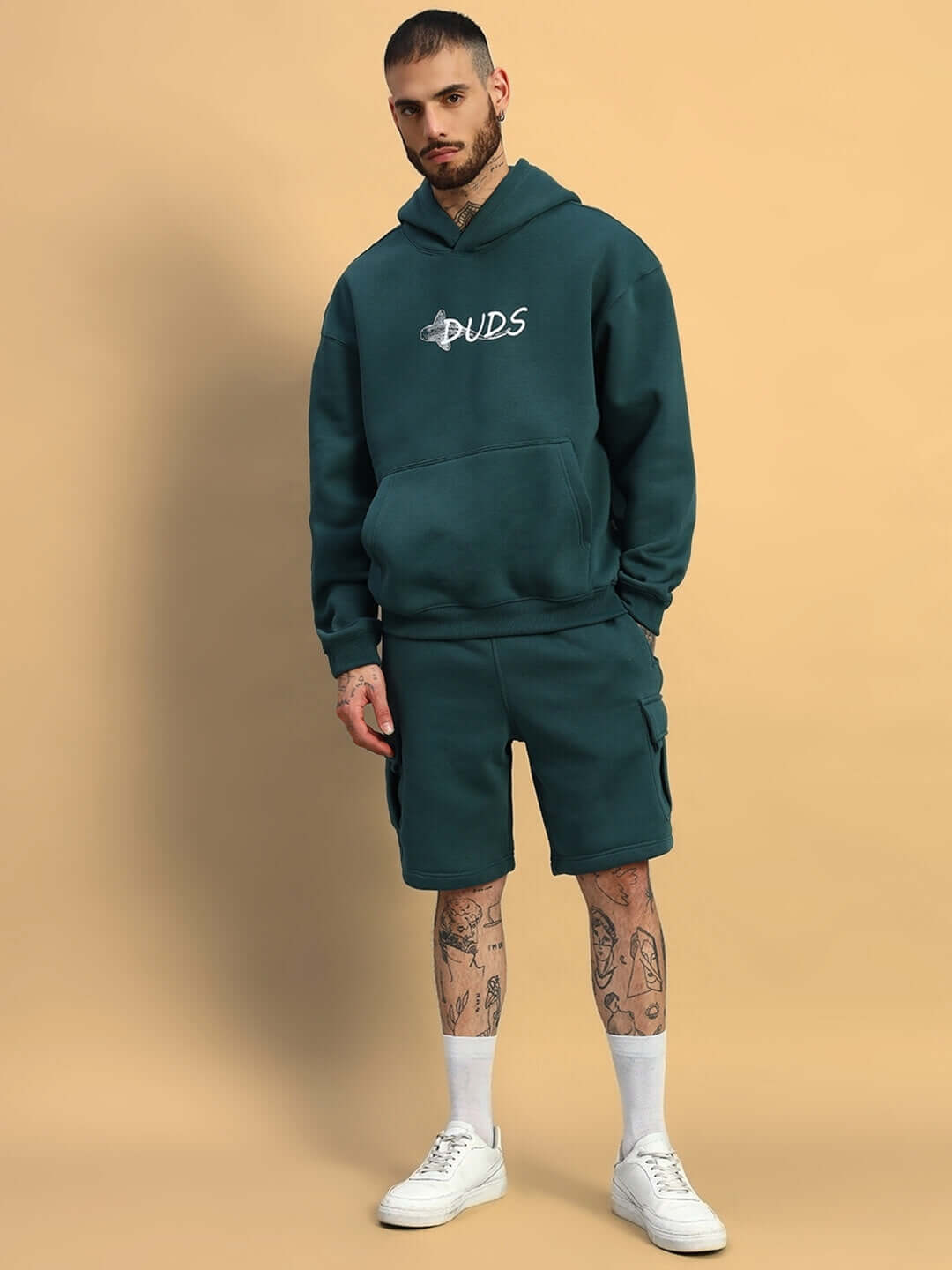 Man wearing HUSKY FLEECE SOLID CARGO SHORTS TEAL GREEN with matching hoodie, showcasing casual comfort and style.