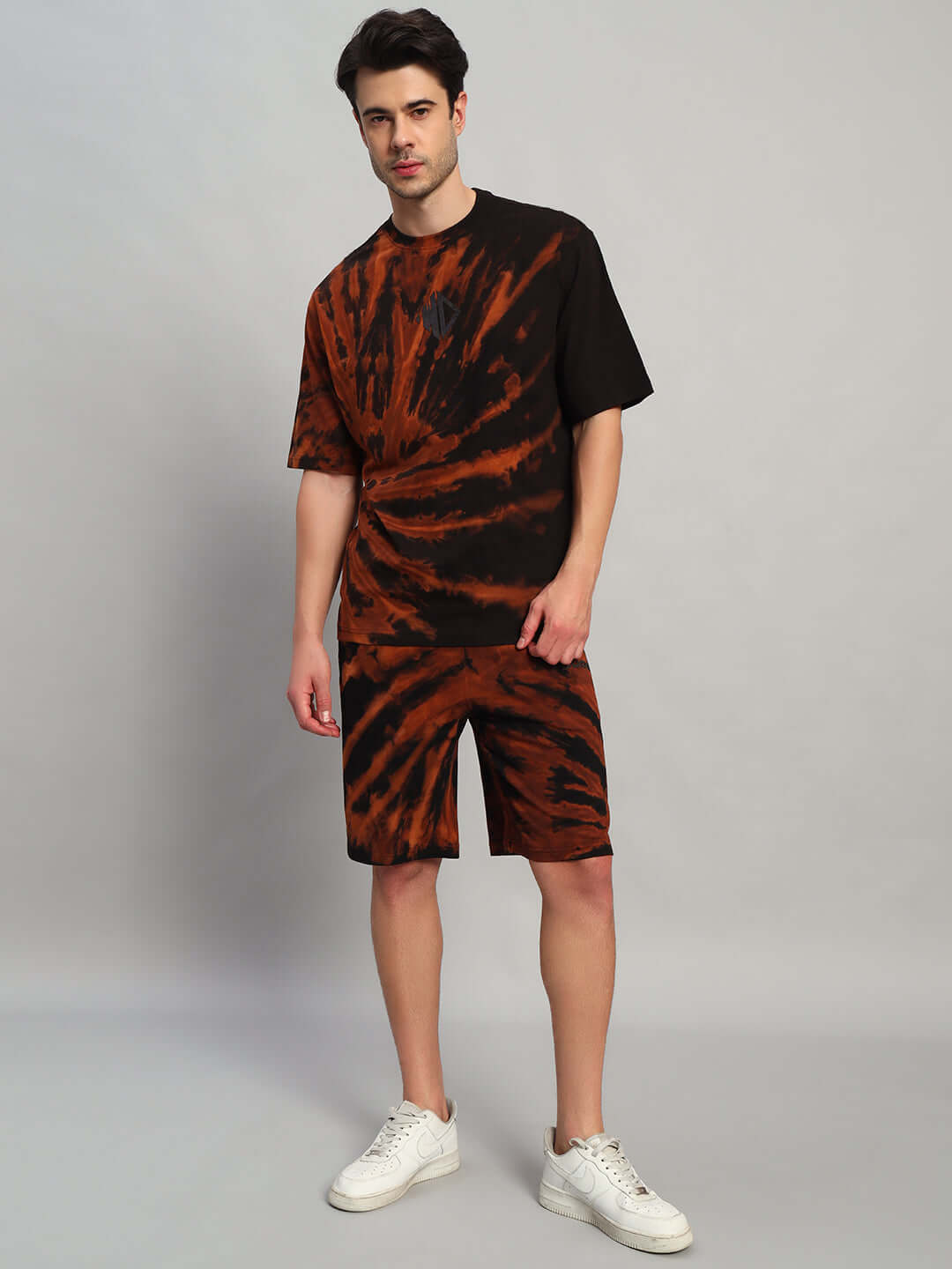 Man wearing a HUSTLER black tie-dye co-ord set made of premium cotton terry fabric, featuring a t-shirt and shorts.