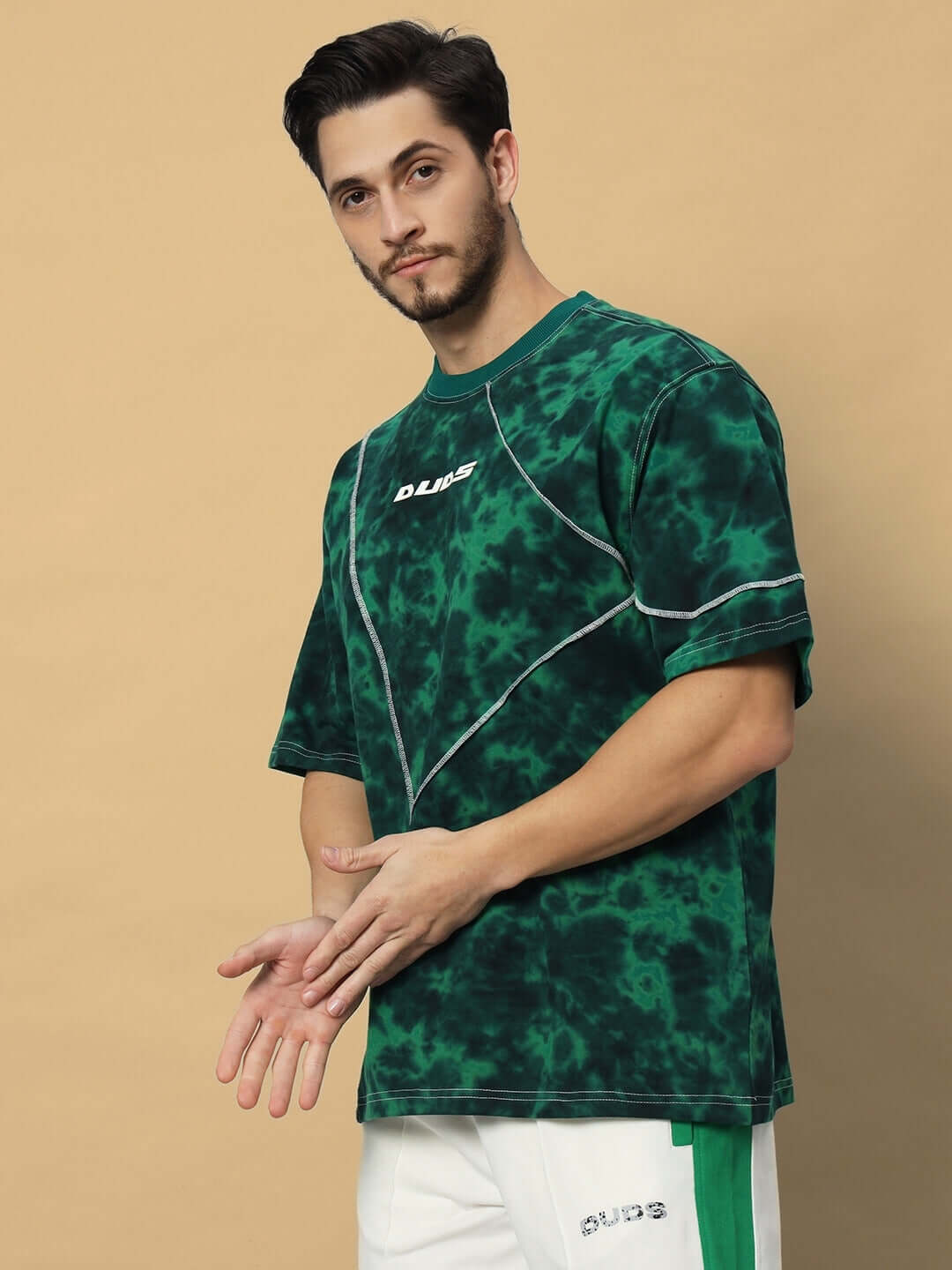 Man wearing iconic green tie-dye oversized t-shirt made from premium cotton, highlighting stylish design and comfortable fit.