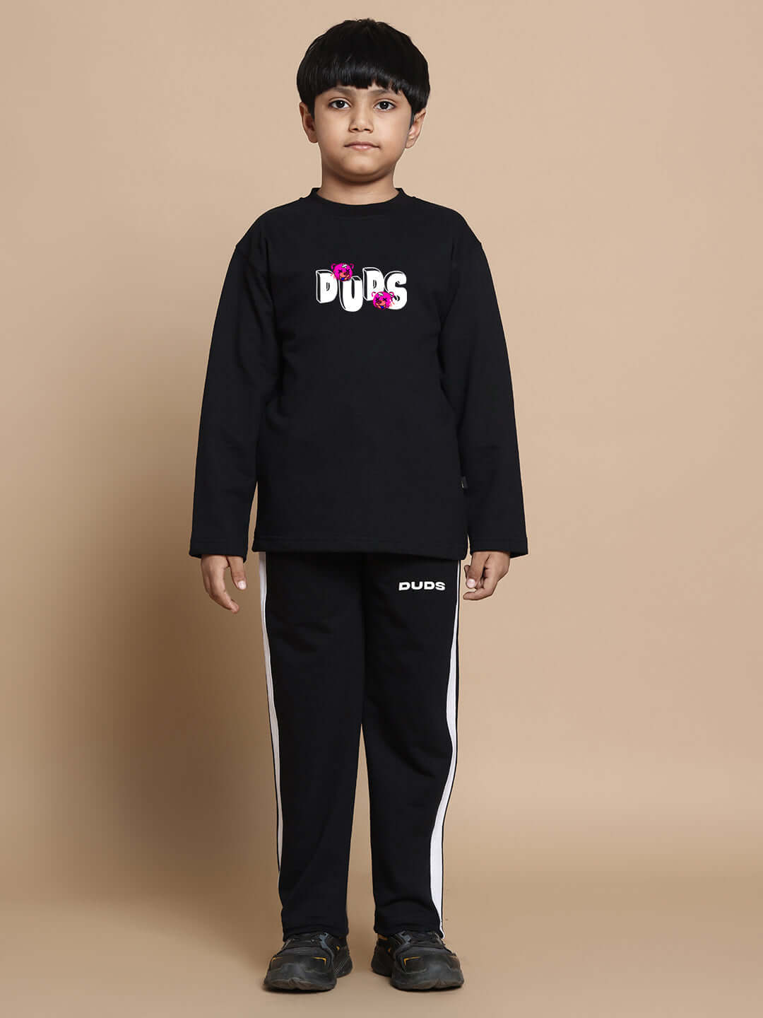 Unisex black co-ord set with a relaxed fit, featuring joggers with elastic waistband and drawstring, worn by child, suitable for boys and girls.