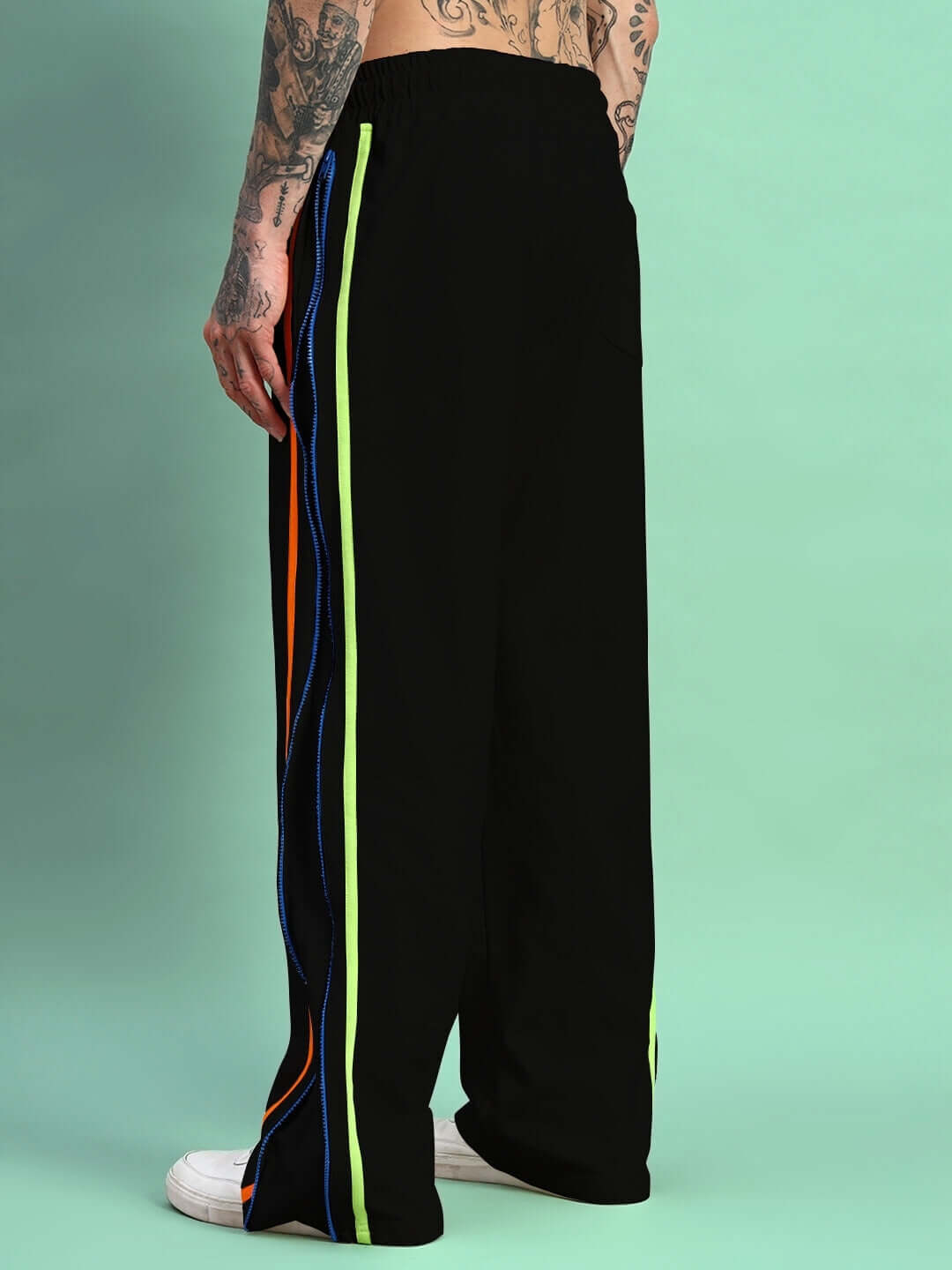 Side view of person wearing Imperial Side Zipper Joggers in black with colorful side stripes, featuring a casual fit style.