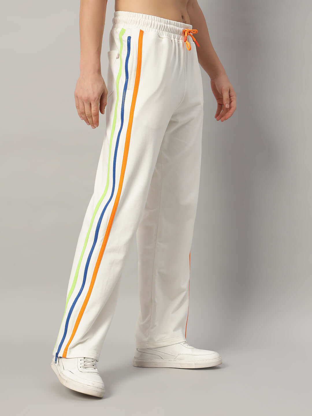 Model wearing off-white Imperial joggers with colorful side stripes and white sneakers.
