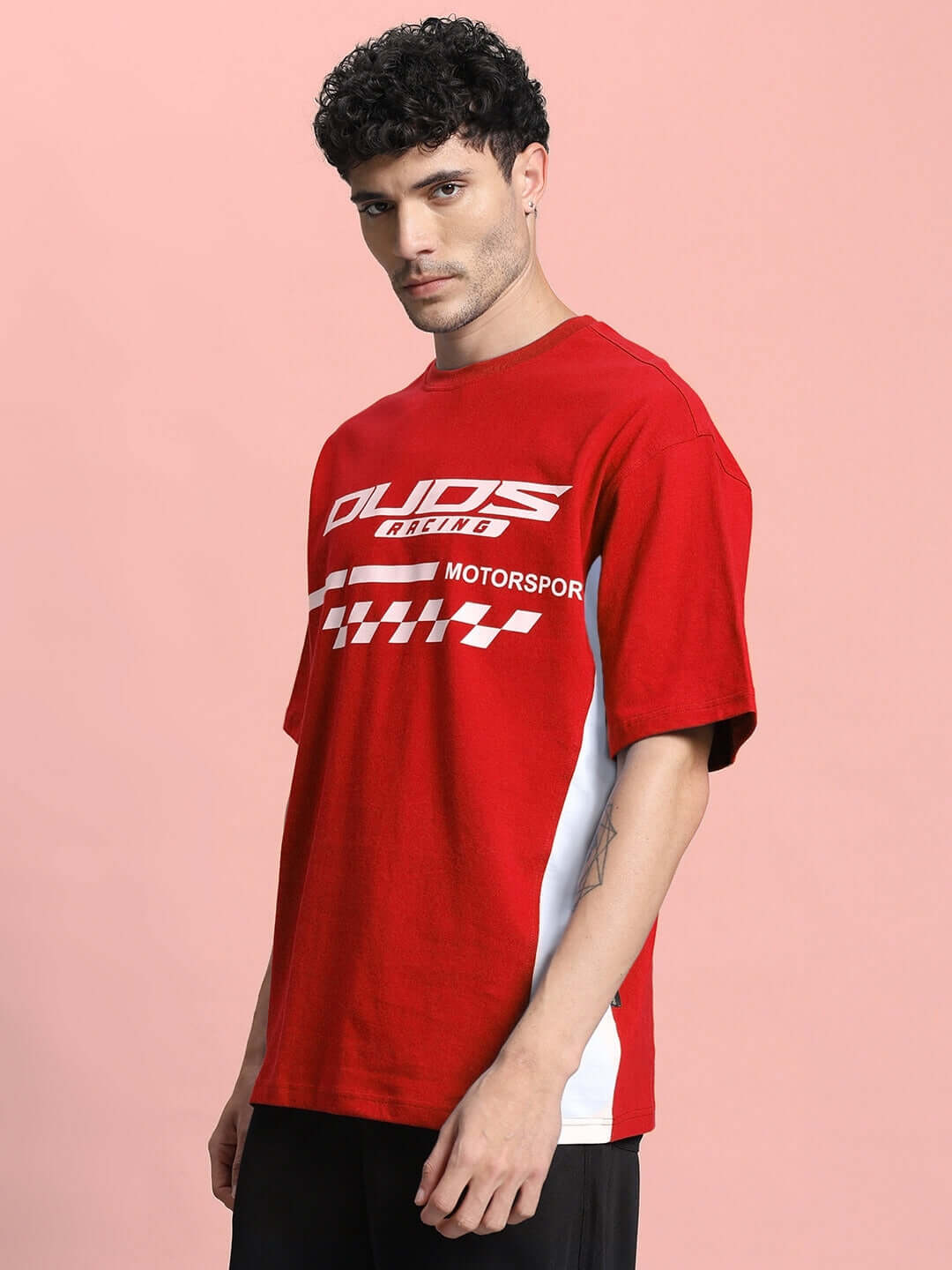 Man wearing INDY OVER-SIZED CLASSIC T-SHIRT RED, showcasing premium cotton streetwear with a sporty design.
