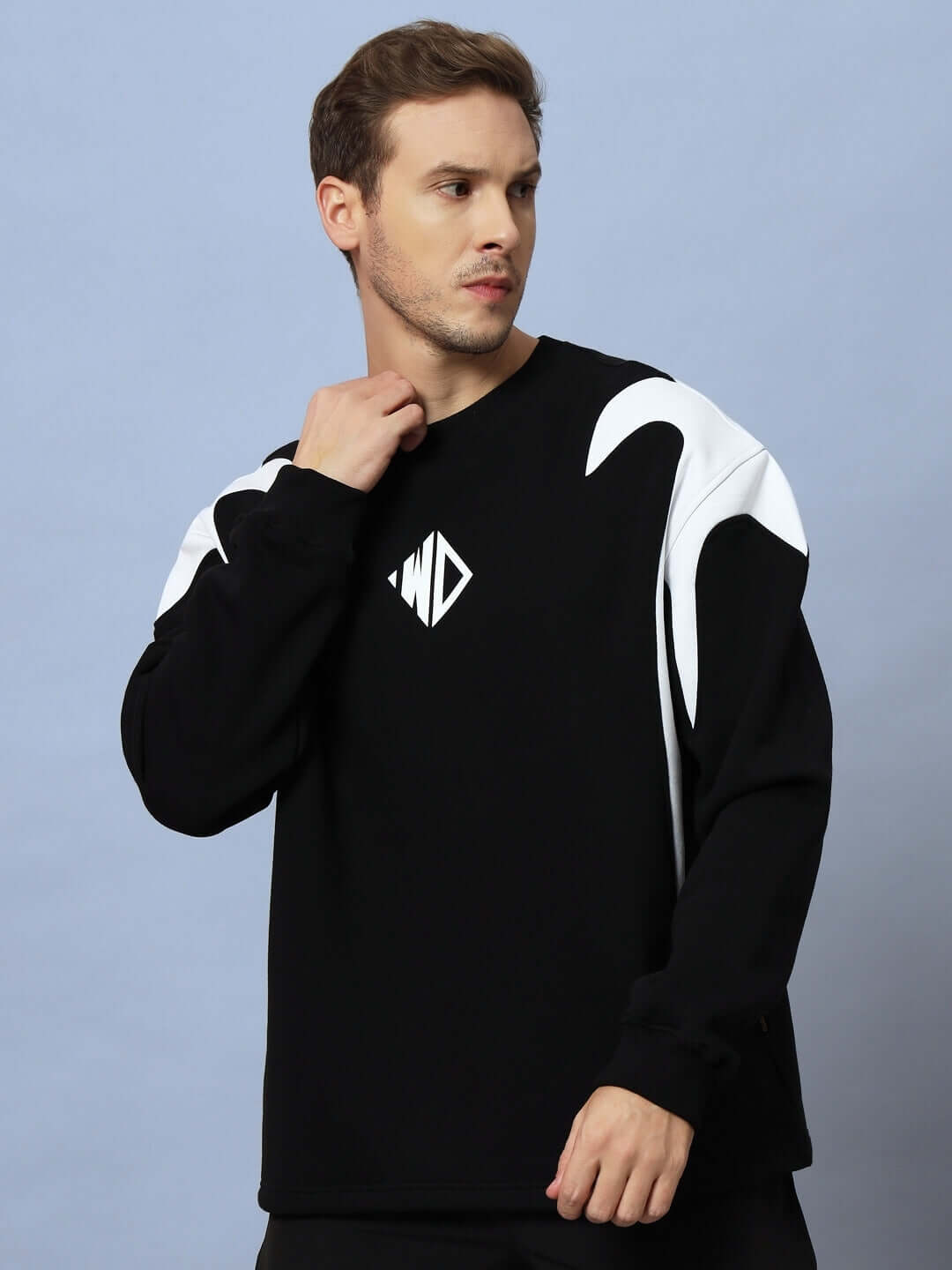 Man wearing INFINITY SAGA OVERSIZED FLEECE SWEATSHIRT BLACK with white design, showcasing casual streetwear style.
