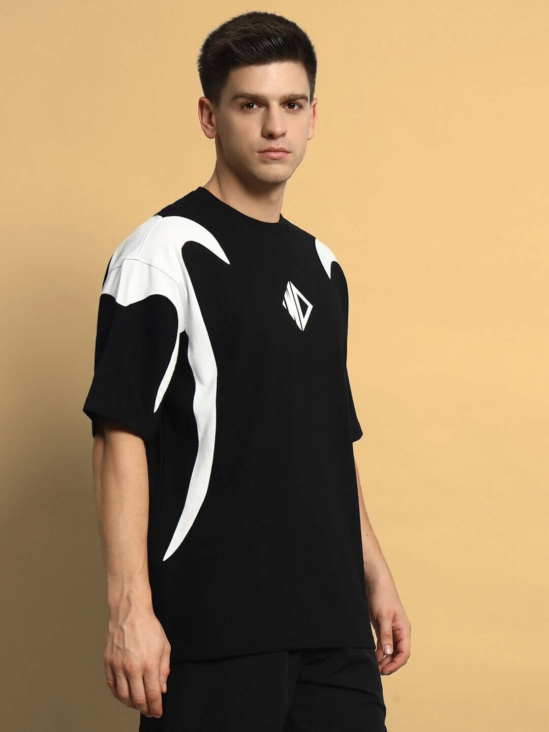 Model wearing INFINITY SAGA oversized black t-shirt, premium cotton French terry, side view, designed for comfort and style. Made in India.