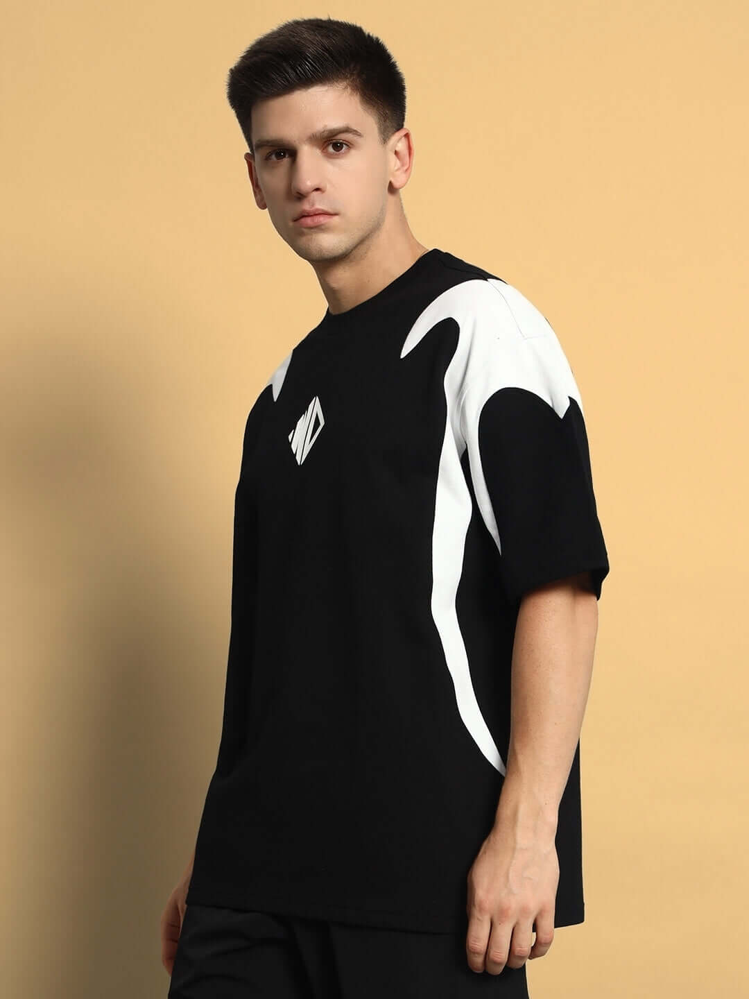 Model wearing Infinity Saga oversized black t-shirt made of premium cotton fabric, featuring distinctive white patterns and relaxed fit.