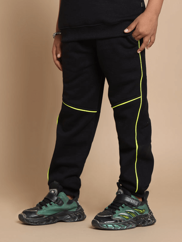 Black children's jogger pants with yellow accents, styled with trendy shoes, suitable for boys and girls.