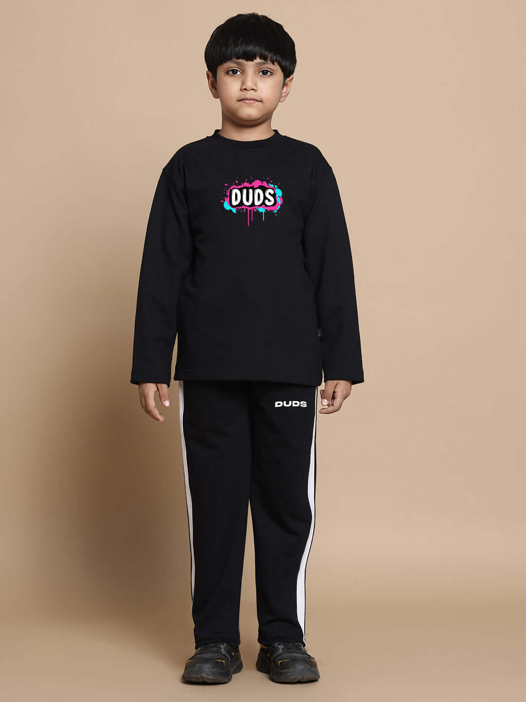 Child wearing unisex INSANE RABBIT black co-ord set with joggers and long sleeves, featuring 'DUDS' graphic. Made from premium cotton.