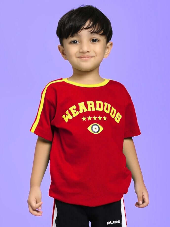 Boy wearing IRISH T-SHIRT FOR BOYS AND GIRLS RED with Irish-themed detailing, stands against a purple background.