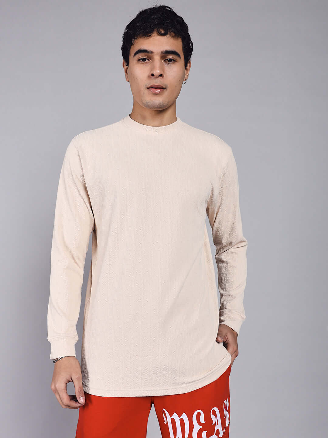 Man wearing a cream JACOB sweatshirt made from premium heavy gauge jacquard lycra fabric, styled with red pants.