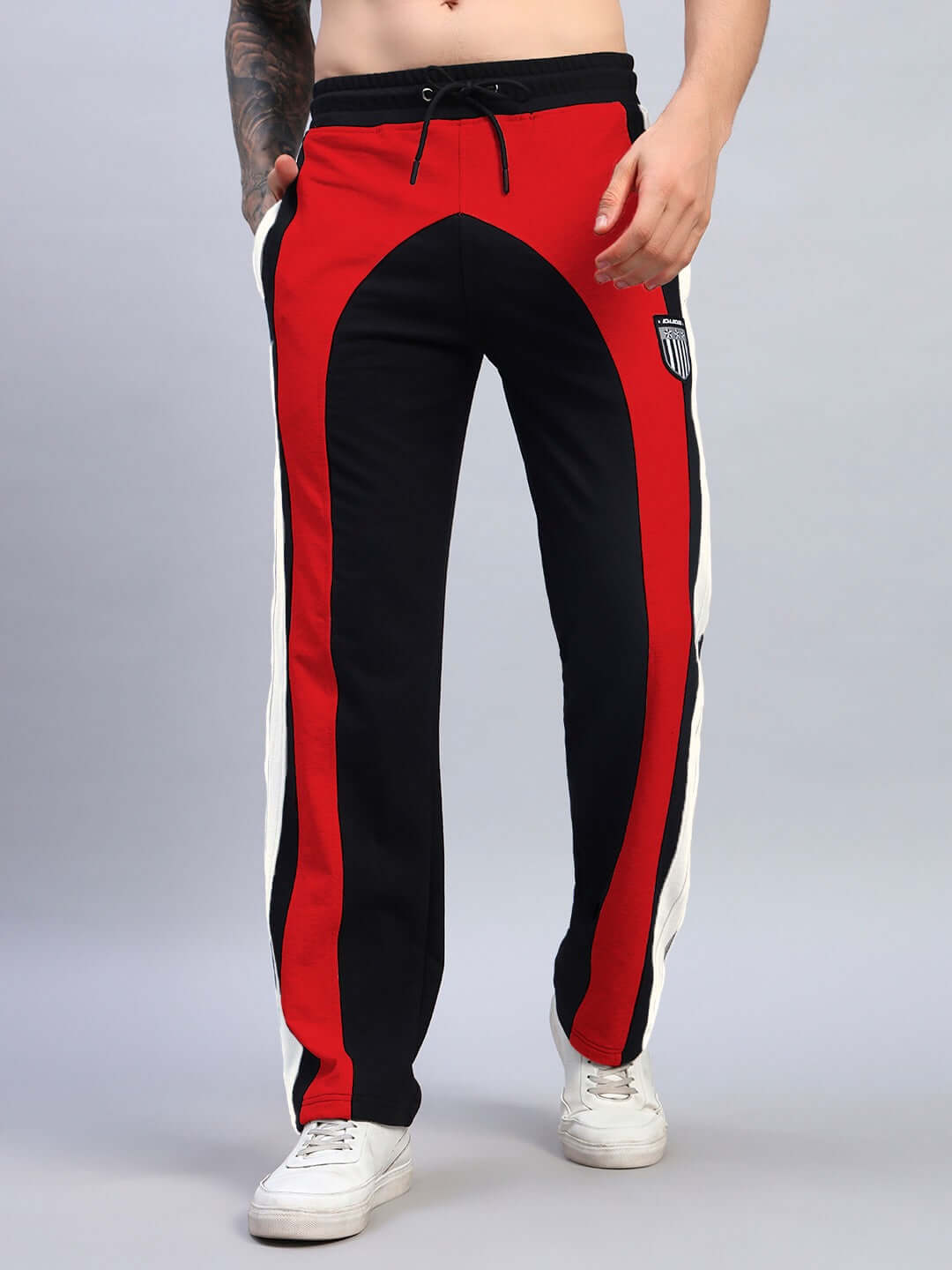 Model wearing JAMISON COLOR BLOCK RELAXED-FIT JOGGERS BLACK RED with vibrant contrast panels, showcasing streetwear style.