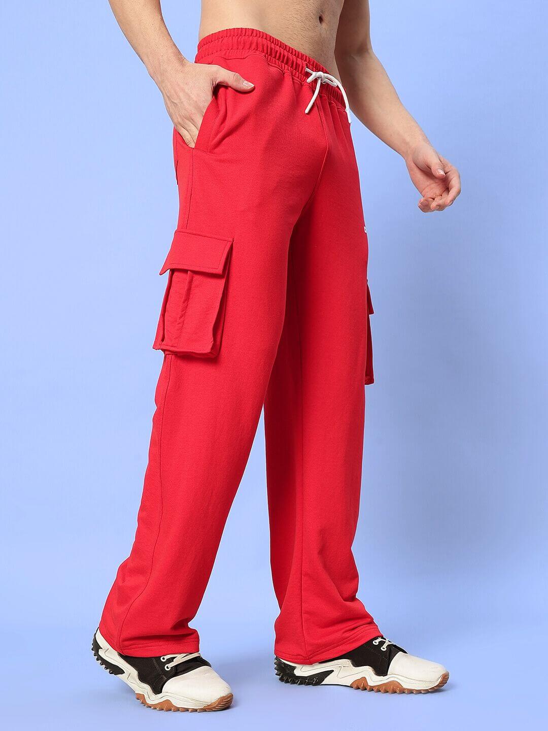 Person wearing JESS 5 POCKET RELAXED FIT JOGGERS RED with casual sneakers against a blue background