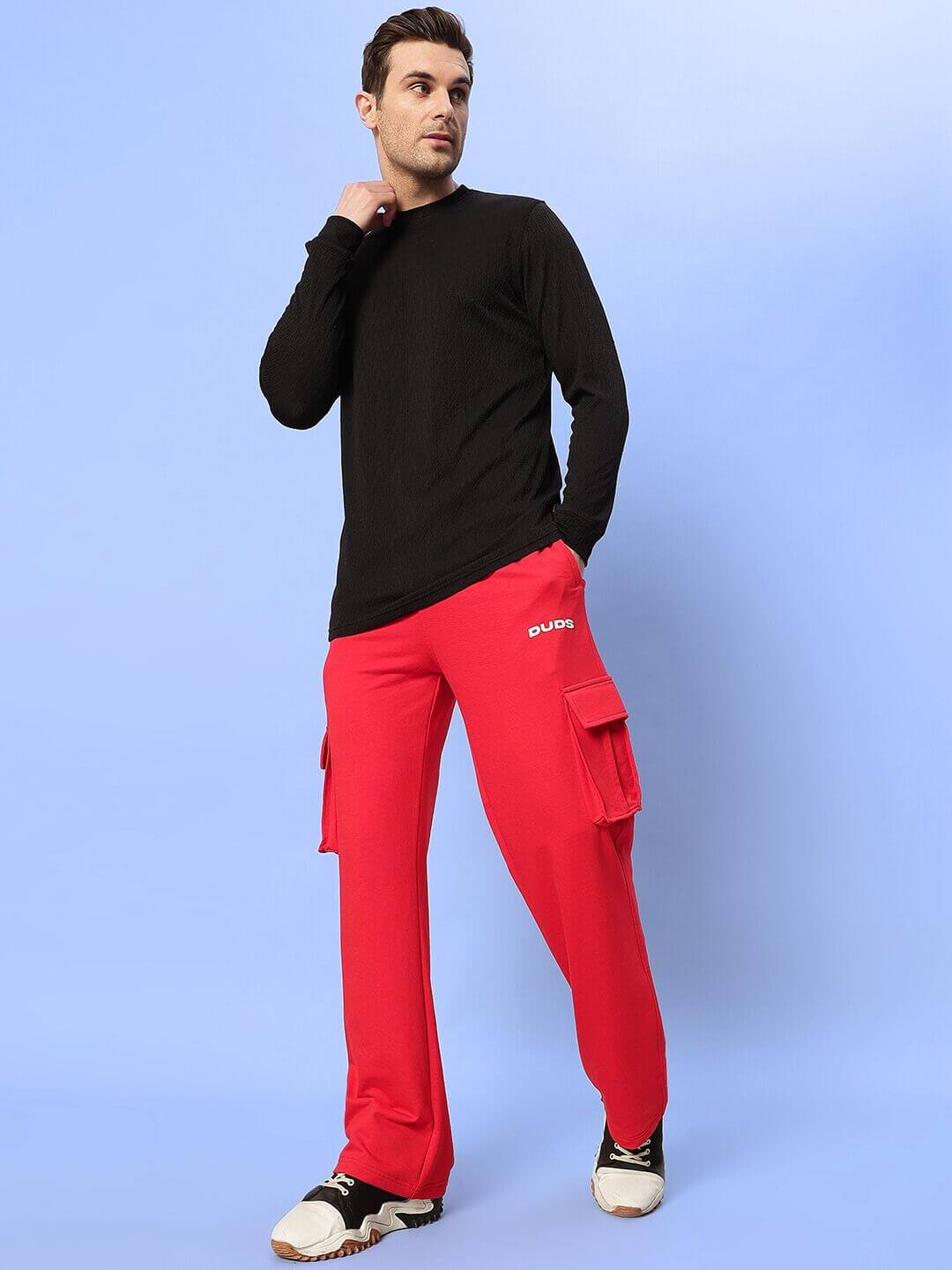 JESS 5 POCKET RELAXED FIT JOGGERS RED worn by a model against a blue background, showcasing bold streetwear style and comfort.