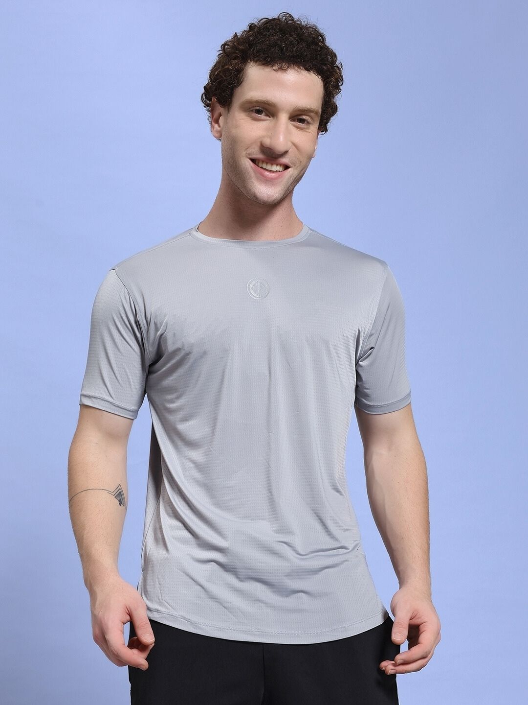 Man wearing JET RUN REGULAR FIT T-SHIRT GREY against a blue background