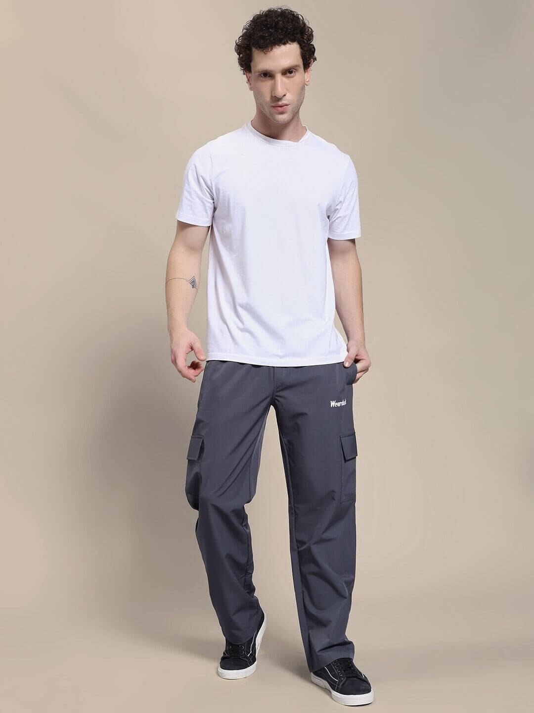 Man wearing JIMMY RELAXED FIT MULTI POCKET JOGGER DARK GREY with white t-shirt, showcasing casual street style and utility design.
