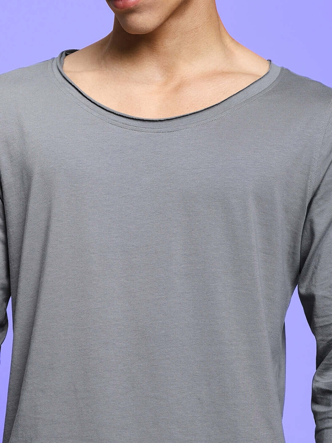 Grey slim fit sweatshirt made of 100% cotton, shown on model against a purple background. Fashionable and comfortable design.