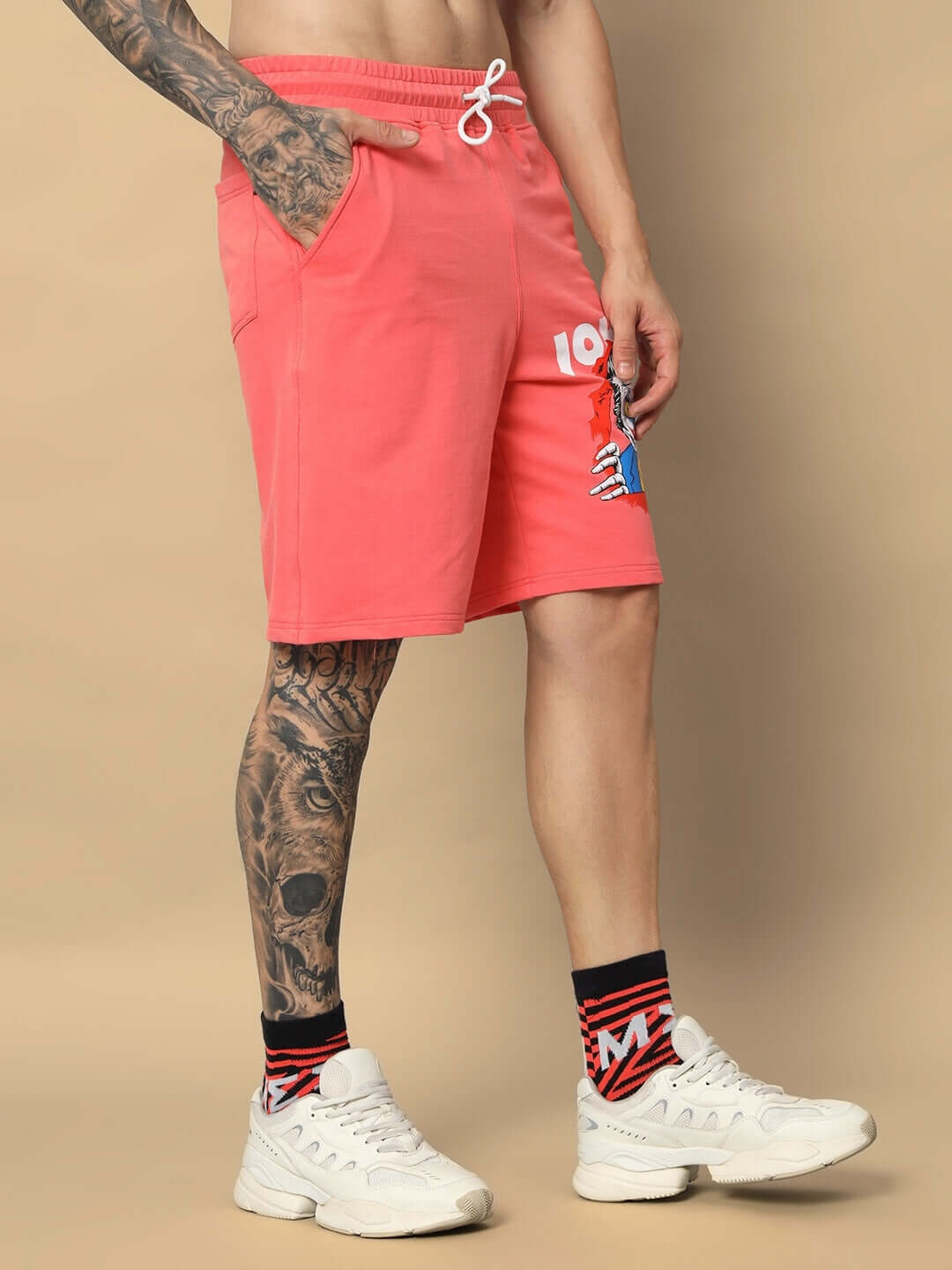 Model wearing Joker Regular Fit Shorts in Pantone Peach with tattooed leg and white sneakers