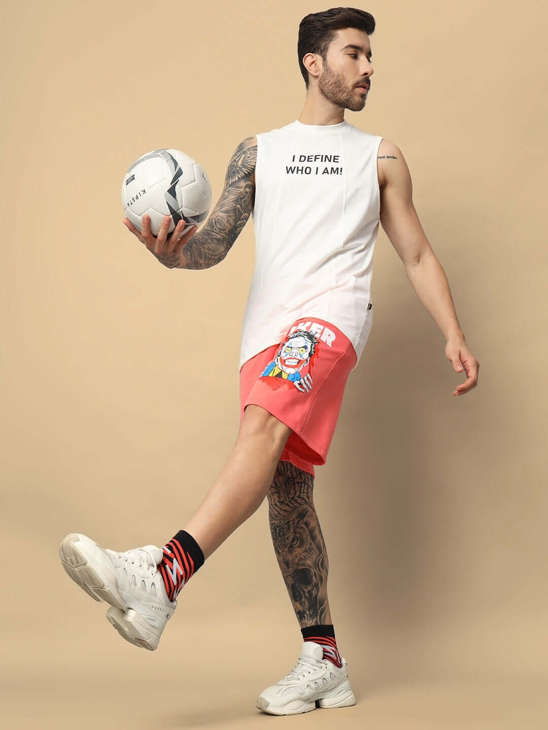 Man wearing Joker Regular Fit Shorts in Pantone Peach, holding a soccer ball, showcasing casual athletic style.
