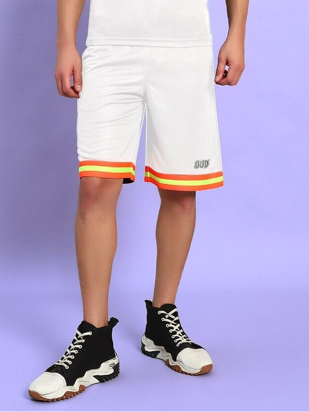 Model wearing JORDAN GYM REGULAR FIT SHORTS WHITE with striped hem, styled with black sneakers on a purple background