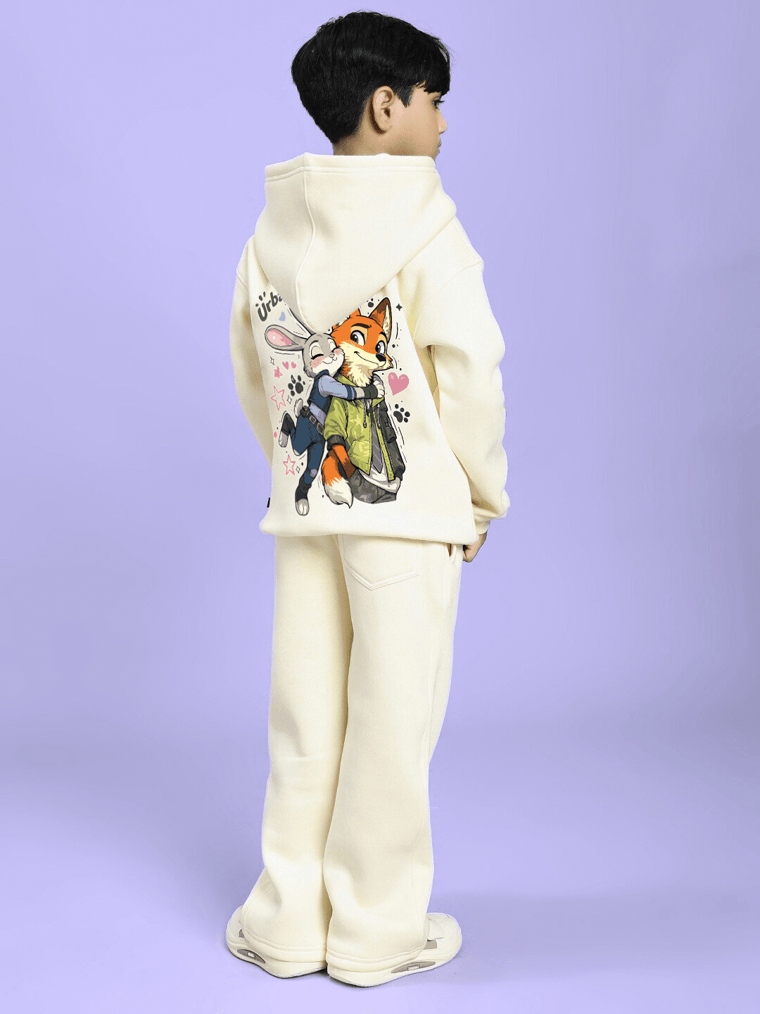Boy wearing JUDY NICK ZOOTOPIA FLEECE CO-ORD FOR BOYS GIRLS OFF WHITE featuring Judy and Nick characters on the back.