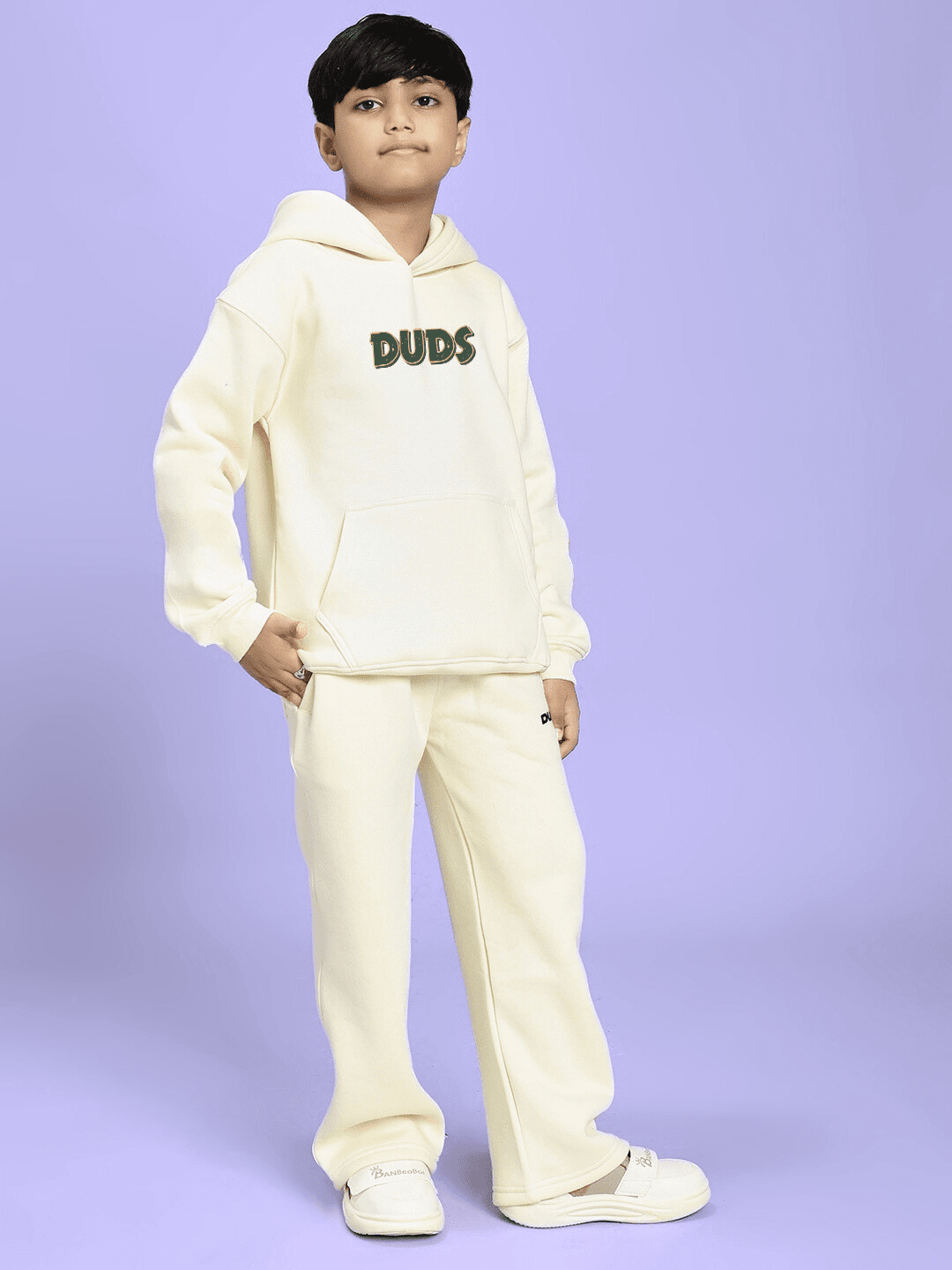 Child wearing JUDY NICK ZOOTOPIA FLEECE CO-ORD FOR BOYS GIRLS OFF WHITE, featuring hoodie and pants against a purple background.