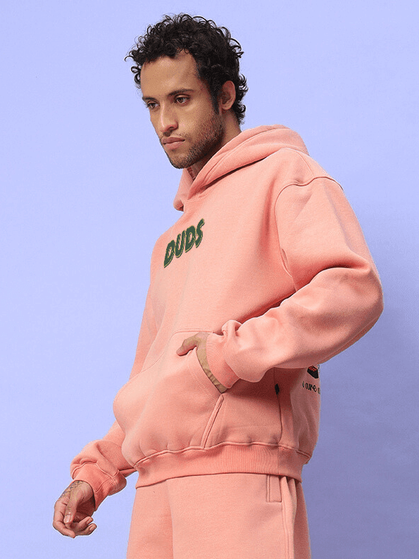 JUDY NICK ZOOTOPIA FLEECE HOODIE PEACH worn by model, showcasing cozy streetwear with iconic characters from the Zootopia movie.