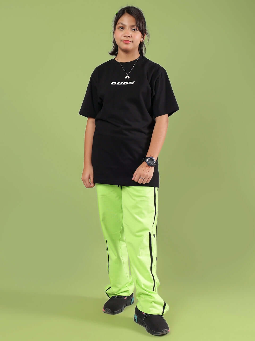 Child wearing JUMBO CO-ORD FOR BOYS & GIRLS BLACK-NEON by DUDS, showcasing black T-shirt and neon pants, made to order.