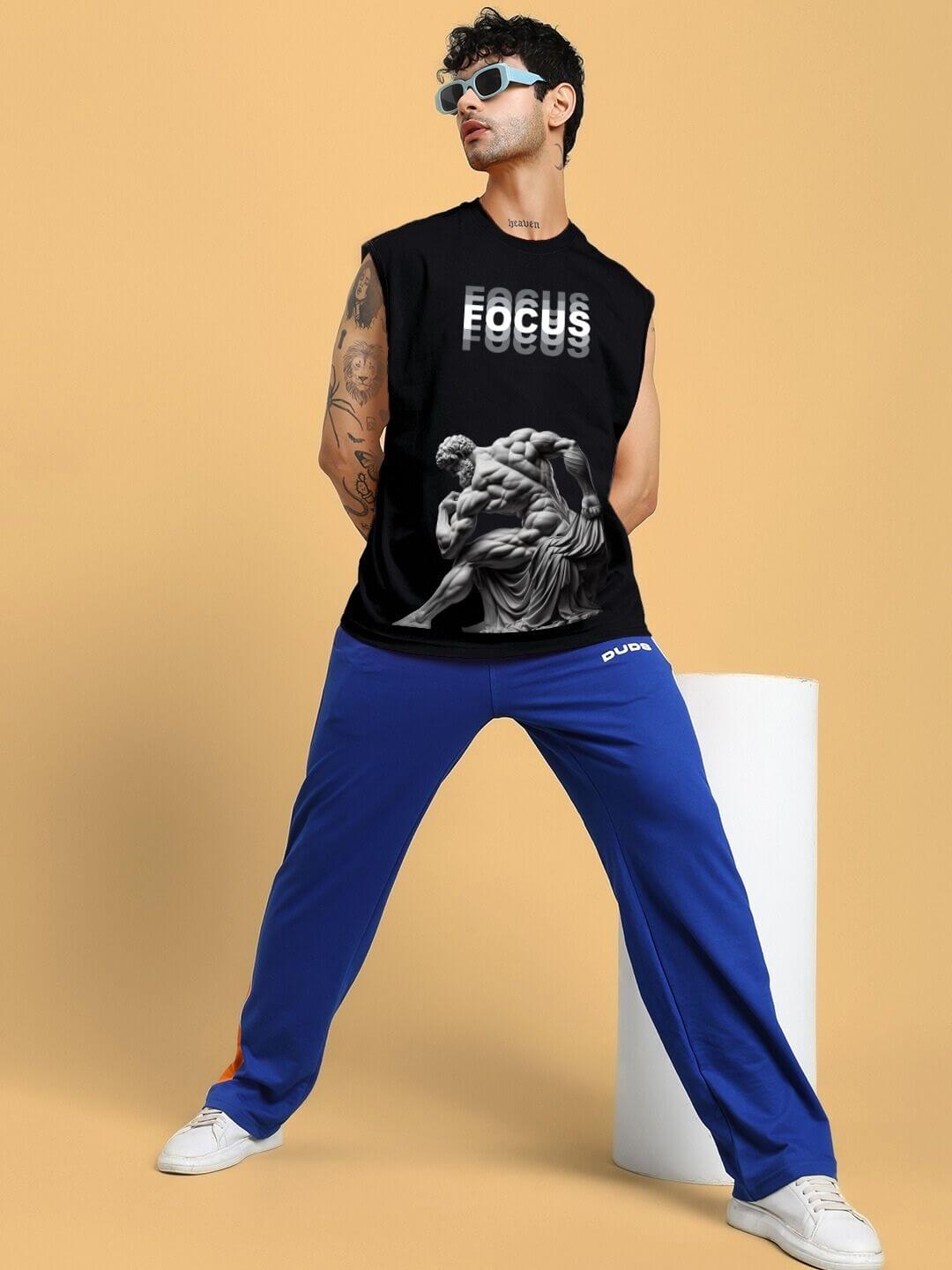 Model wearing JUST FOCUS FINE T-SHIRT in black with custom fit option, featuring artistic graphic print, styled casually with blue pants.