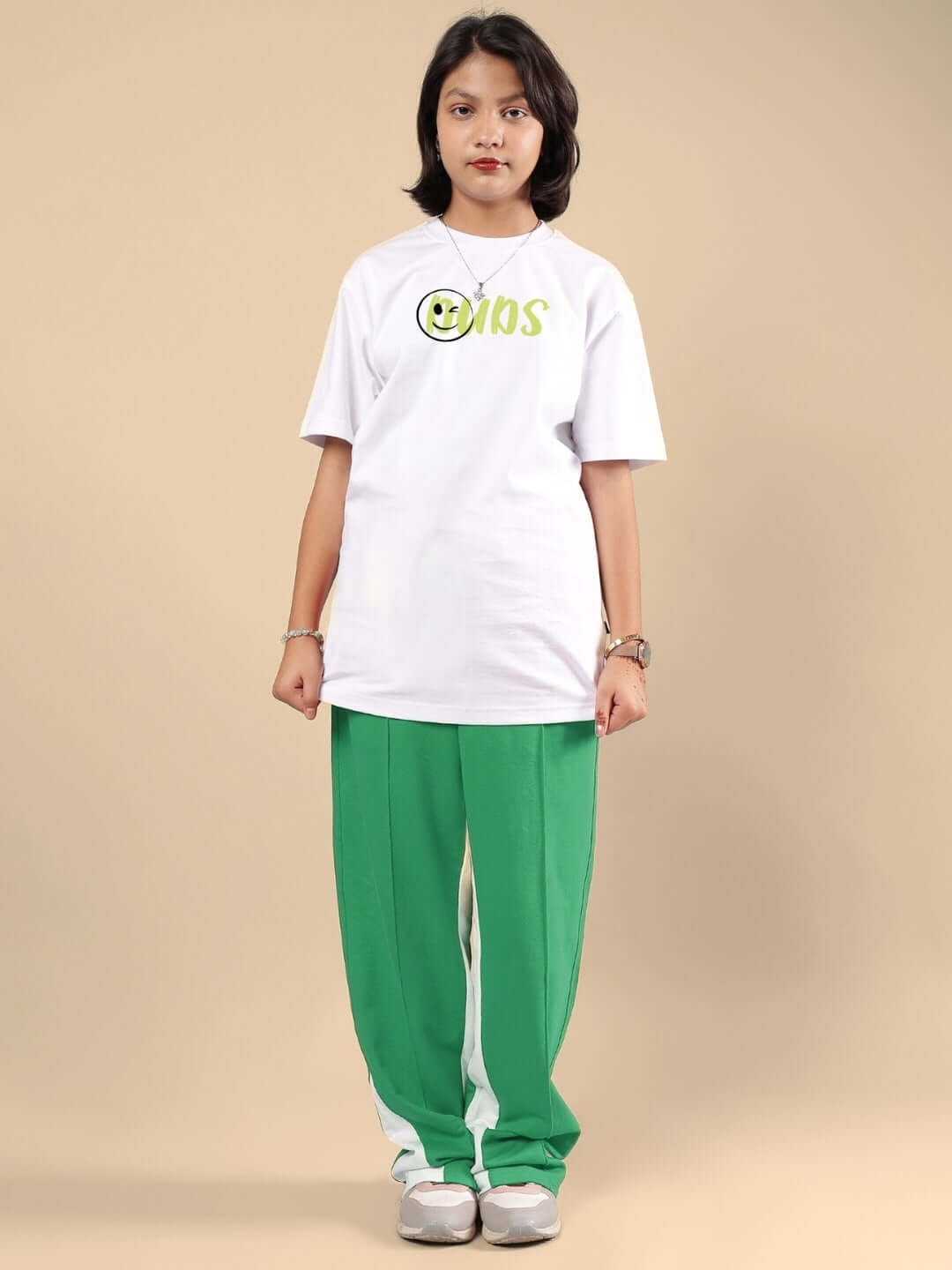 Child wearing JUST WANNA BE CO-ORD FOR BOYS & GIRLS WHITE-GREEN outfit, featuring a white top and green pants, posing fashionably.