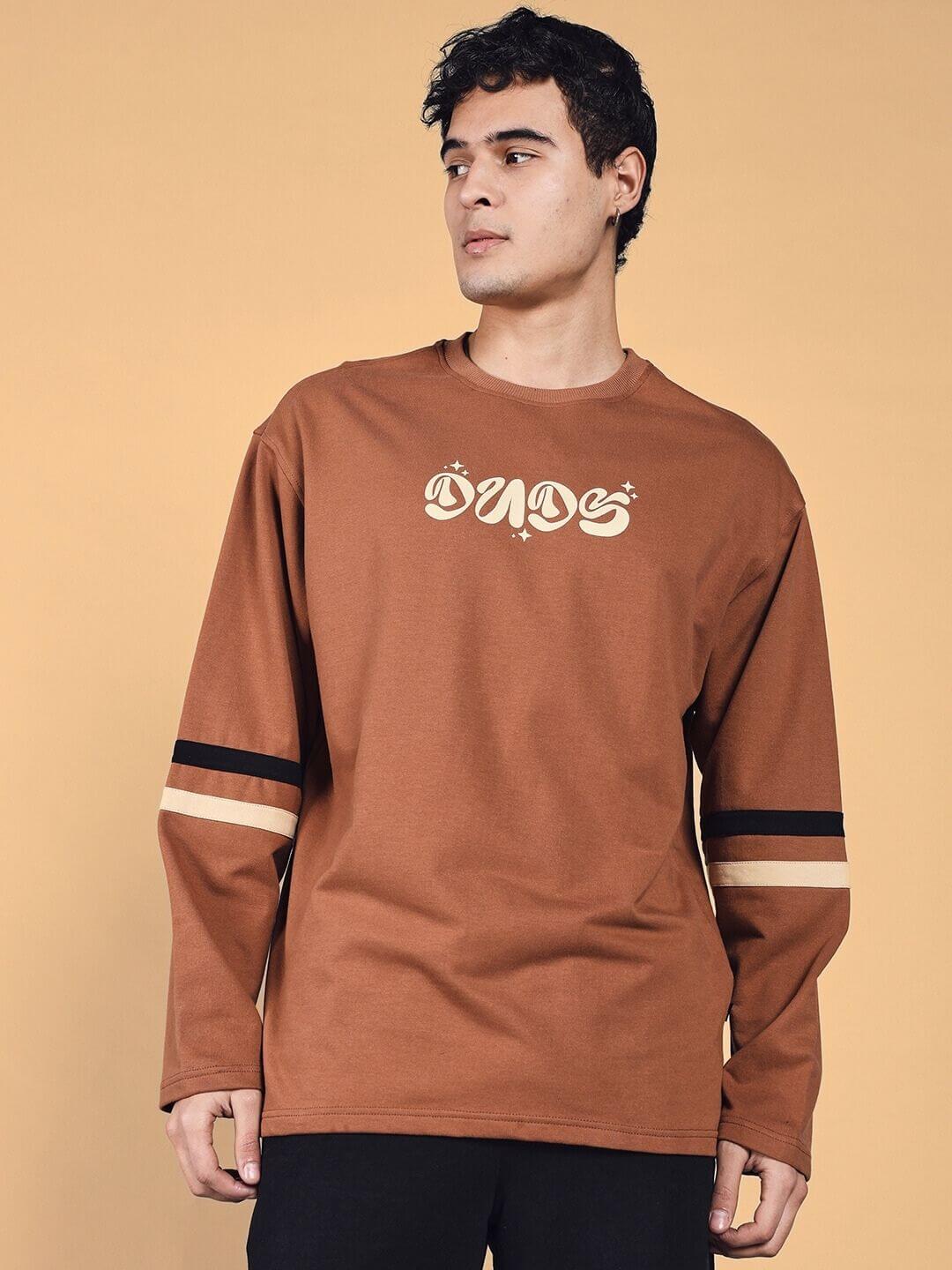 Model wearing a brown oversized KEEP FLYING sweatshirt made with premium cotton terry, featuring bold lettering on the front.