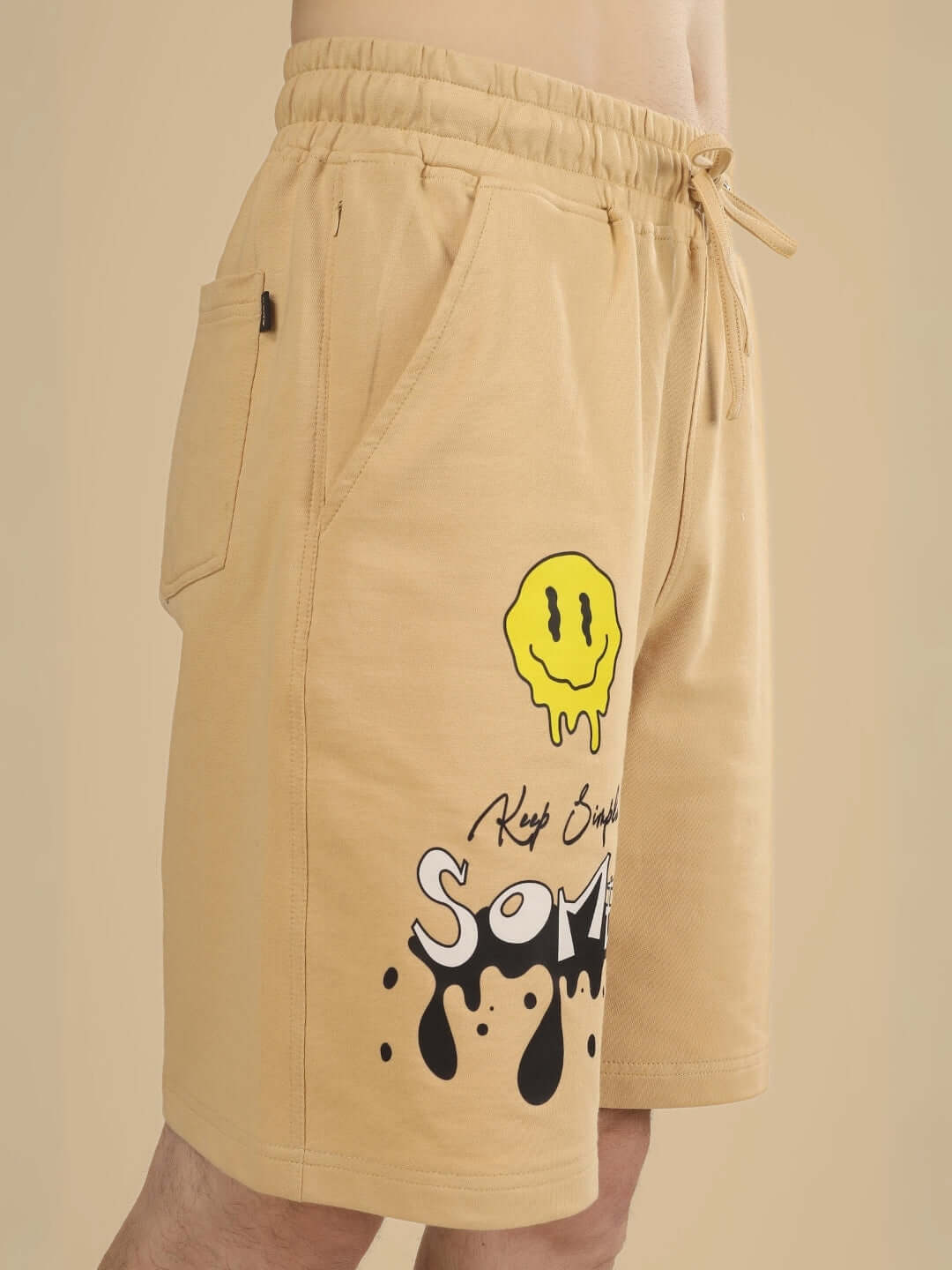 Beige regular fit shorts with smiley design and customization option, featuring drawstring and side pockets for comfort and style.