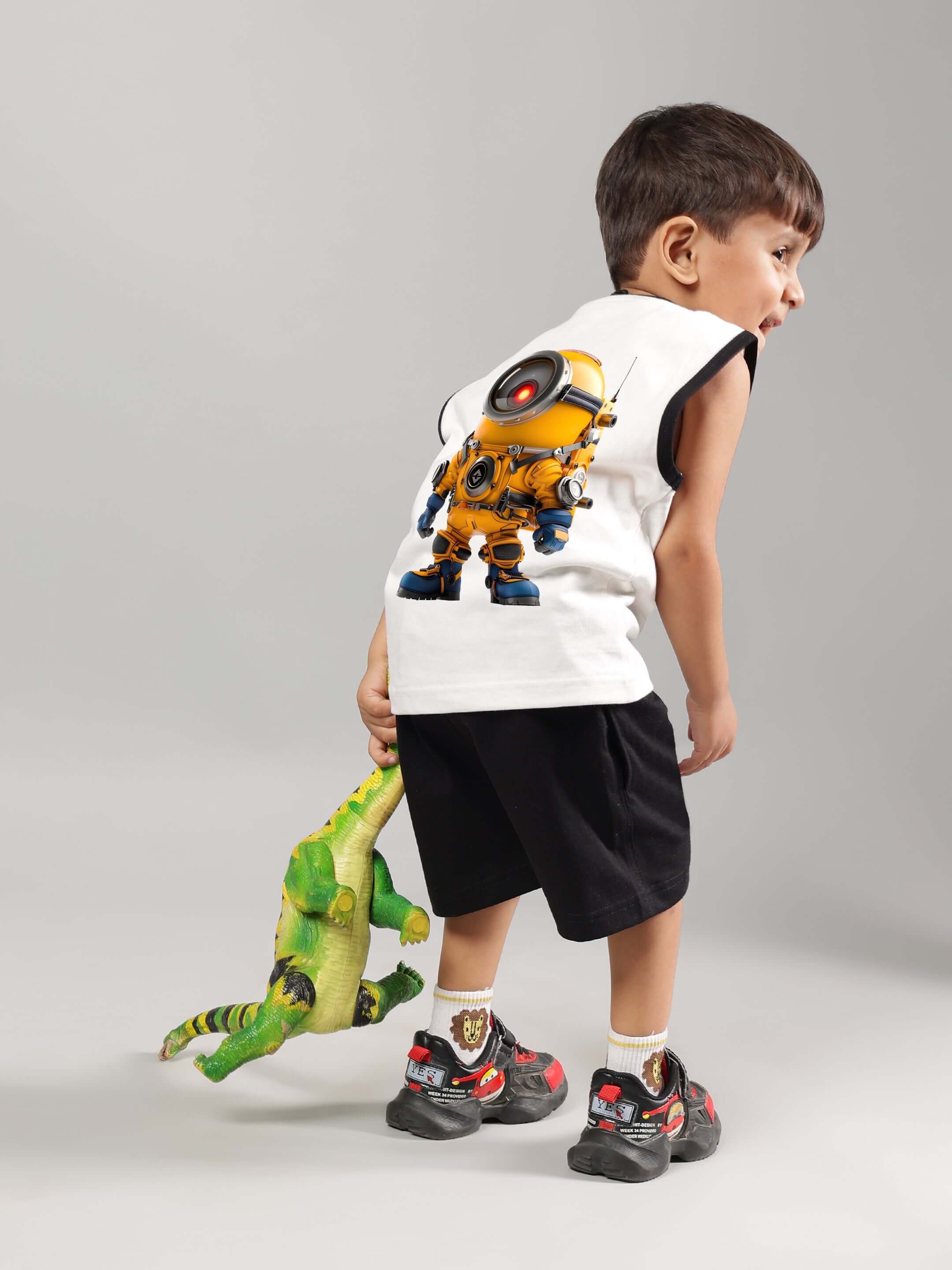 Child wearing Kevin Summer Co-ord in off-white and black playing with a plush toy, featuring a robot print on the top.