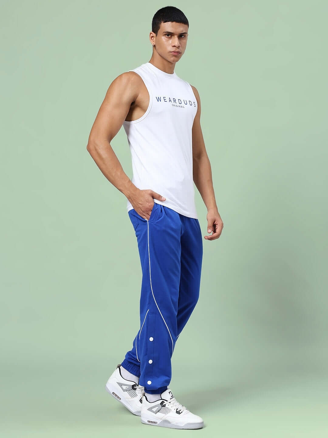 Model wearing KICKSHAW RELAXED FIT CO-ORD SET WHITE-R BLUE, featuring unisex relaxed fit joggers with elastic waistband and drawstring.