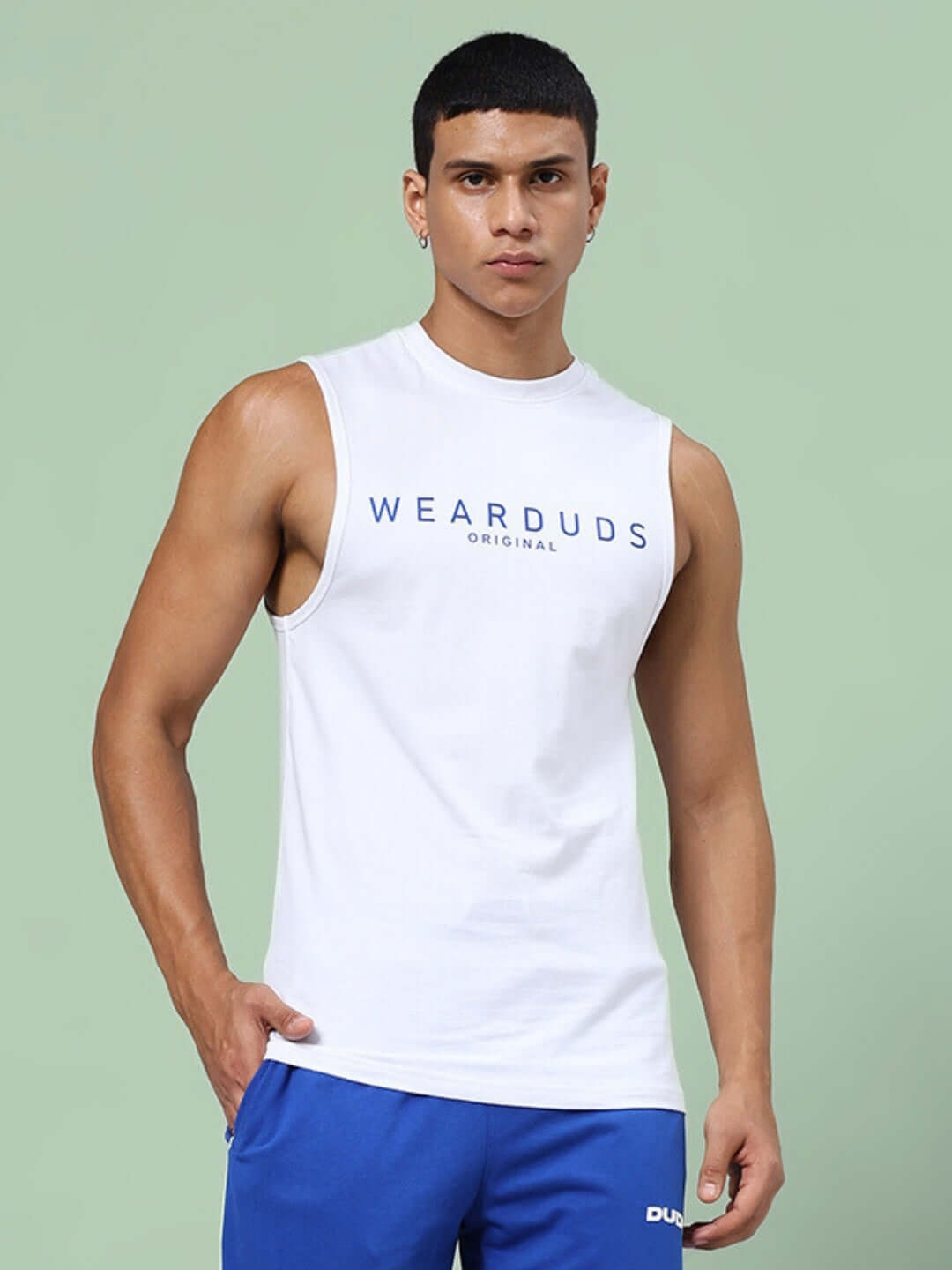 Man wearing Kickshaw white gym t-shirt with 'WearDuds Original' print, displaying athletic fit and design features.