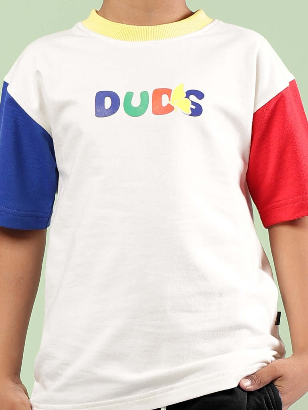 Close-up of a child wearing a colorful t-shirt with 'DUCKS' text, featuring blue, red, and white sections.
