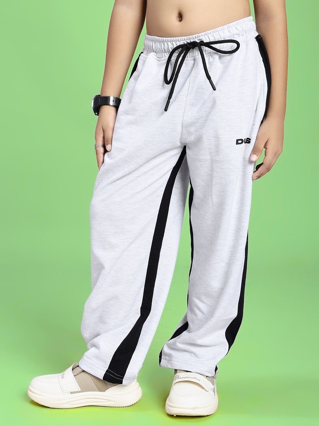 SIDE SEAM BAGGY JOGGER FOR BOYS AND GIRLS GREY BLACK with drawstring waistband displayed on model against green background.