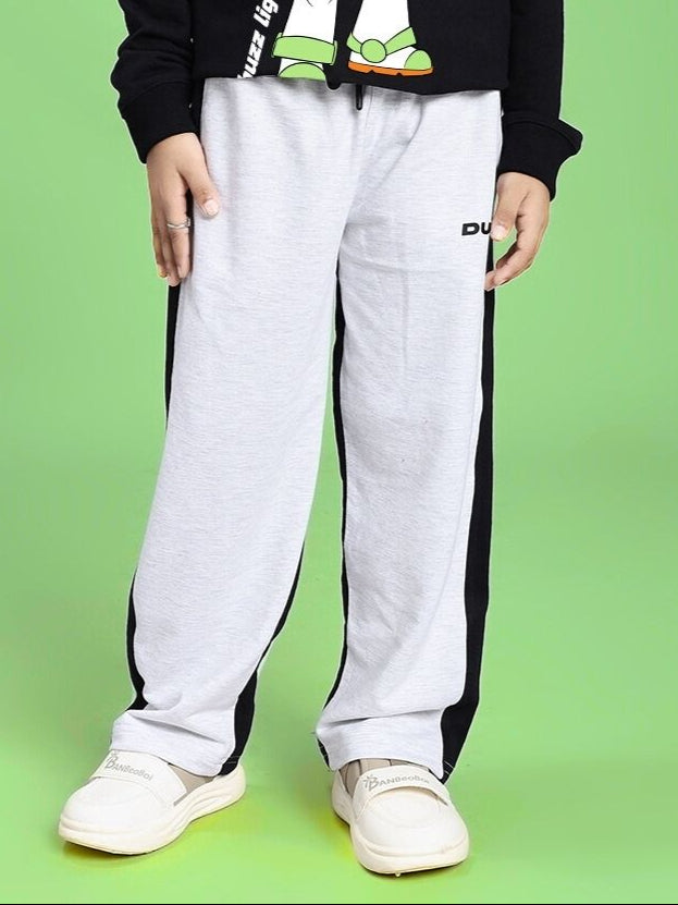 SIDE SEAM BAGGY JOGGER FOR BOYS AND GIRLS GREY BLACK worn by child on green background