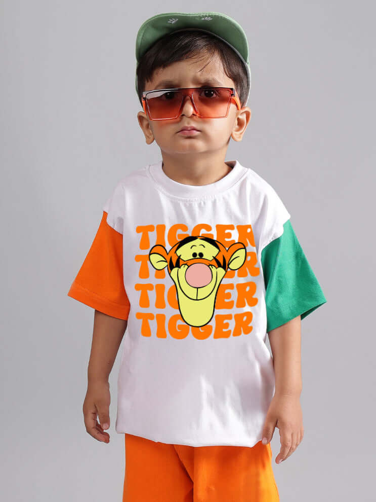 Child wearing a white oversized tiger print t-shirt with colorful sleeves, sunglasses, and a green cap, showcasing kids' fashion style.
