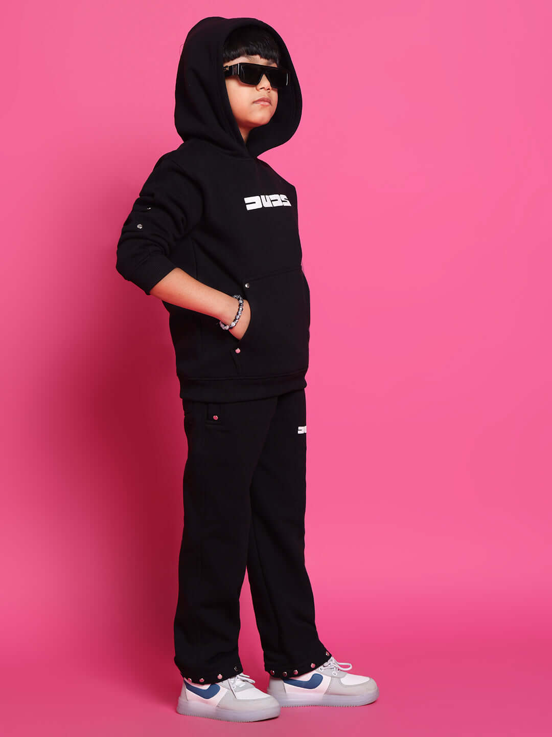 Child wearing DUDS black shooter co-ord set, featuring a hoodie and pants, perfect for boys and girls. Made to order and customizable.