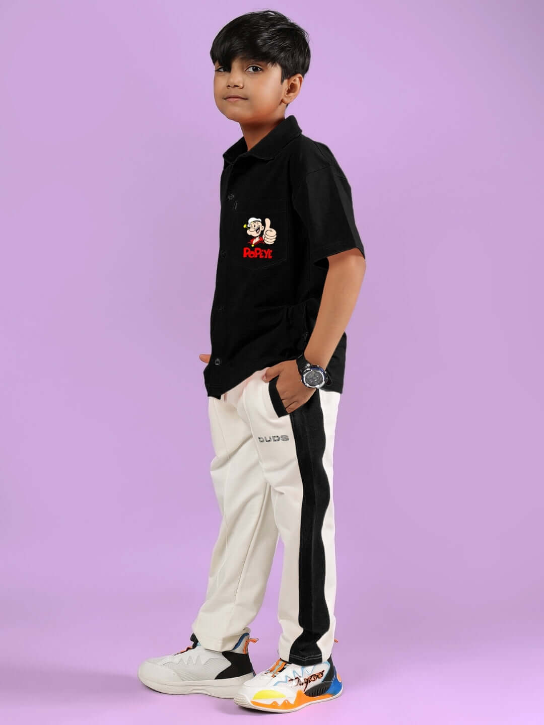 Young boy wearing POWER KIDS CO-ORD FOR BOYS & GIRLS BLACK-OFF-WHITE on a purple background.