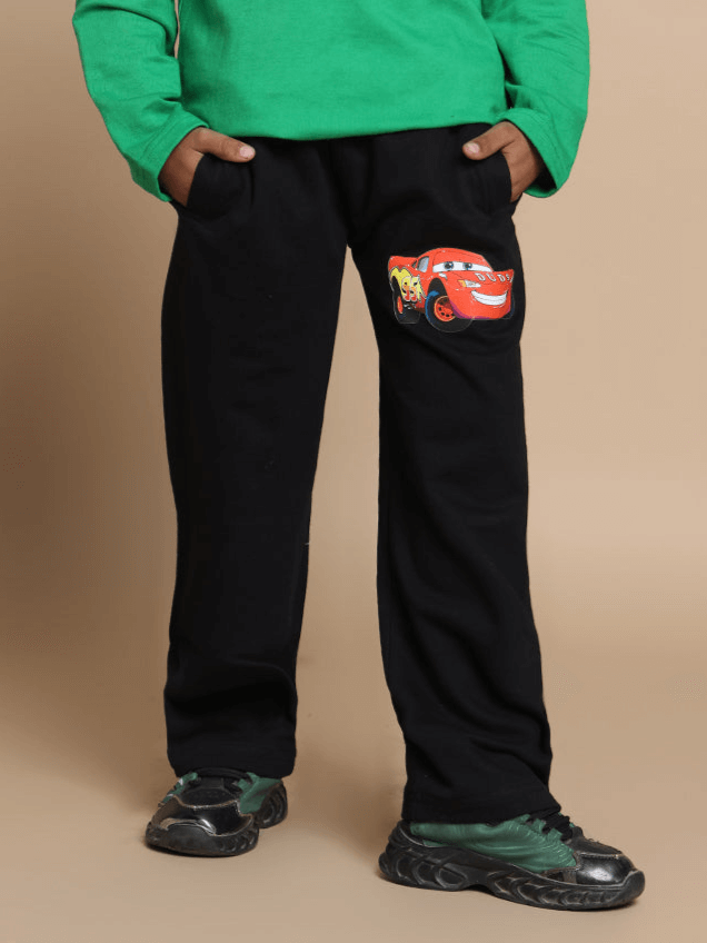 Child wearing black Formula 1 joggers with car graphic, hands in pockets, showcasing comfortable fit for boys and girls.
