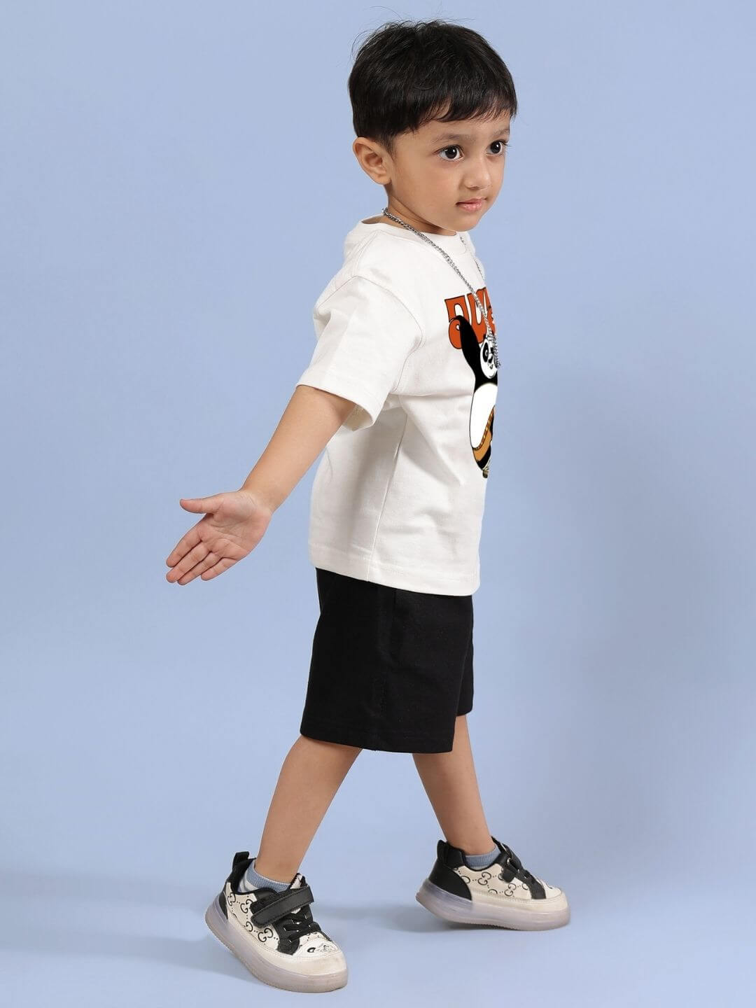 Young child wearing off-white Kung Fu Panda t-shirt and black shorts set, perfect for casual outings and play in soft, breathable cotton.