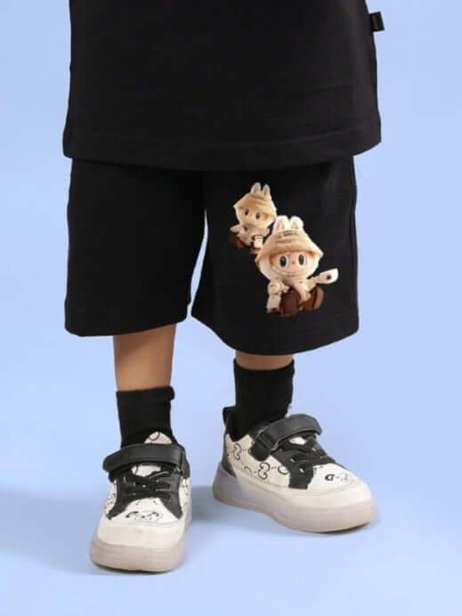 Child wearing LABUBU GANG black shorts with playful character design, paired with black socks and trendy sneakers for boys and girls.