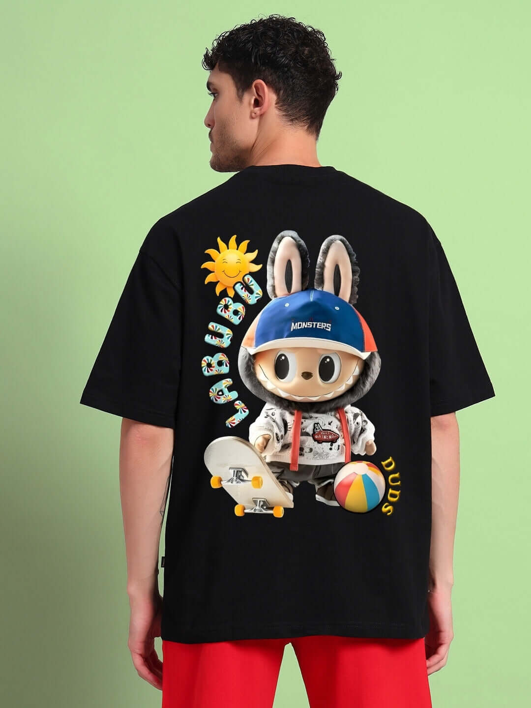 Man wearing LABUBU Monsters oversized black T-shirt featuring colorful cartoon design on back, made of premium cotton fabric.
