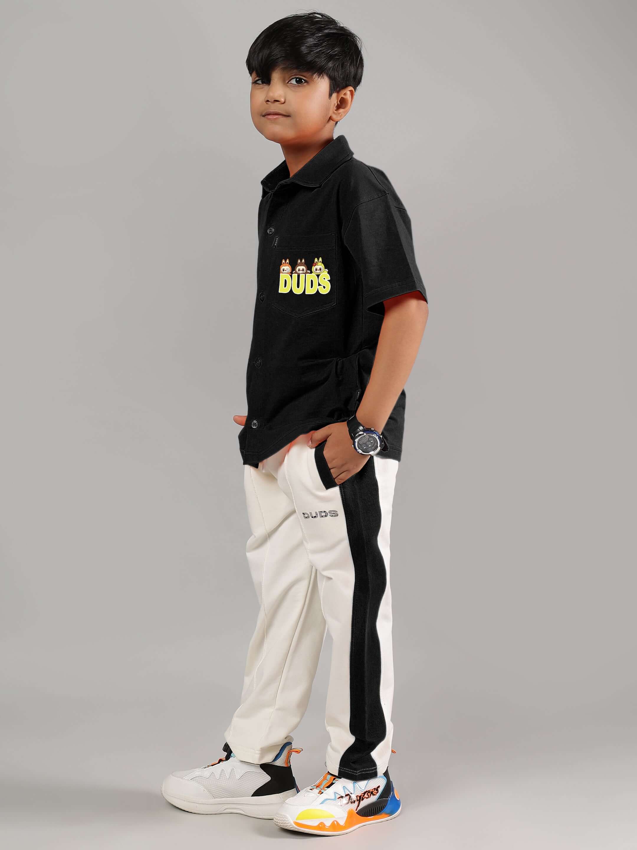 Child wearing LABUBU MYSTERY CO-ORD FOR BOYS GIRLS BLACK-OFF-WHITE, showcasing playful fashion in black and off-white with a watch and sneakers.